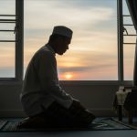 Ilustrasi seorang Muslim berdoa saat Subuh sebagai simbol penguatan iman menghadapi arus globalisasi dan informasi digital.